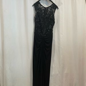 Floor length prom dress. Black. Tight. Small train. Slit in front.